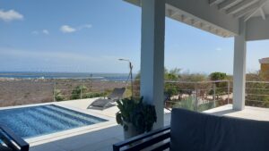 Wiregelænder i rustfrit stål ved pool med havudsigt Pool med rækværk i rustfrit stål og horisontale stålwirer, monteret på terrasse med panoramaudsigt over kyst og hav.