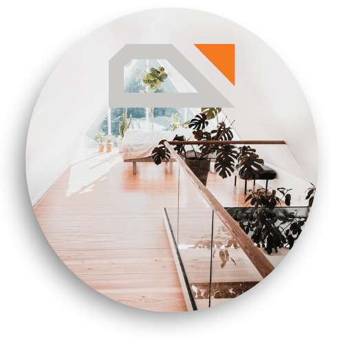 Indendørs glasværn med trædetaljer langs en hems. Lyset fra vinduerne og grønne planter understreger den luftige og naturlige atmosfære.