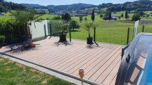 Glashegn med indkigssikring og palmer ved pool Terrasse med frostet og klart glashegn omkring poolområde, kombineret med palmer og fri udsigt over landskabet.