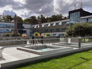 Glashegn omkring hotelpool i bymiljø Poolområde med glashegn ved hotel, installeret med runde stolper og lamineret glas for sikkerhed og elegance.