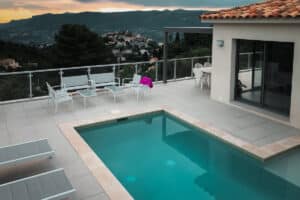 Poolområde med hegn og udsigt i solnedgang Glashegn omkring terrasse og pool ved villa i bjergmiljø – kombination af sikkerhed og panoramaudsigt i eksklusiv ramme.